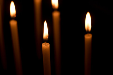 Several candles lit in the dark for religious purposes.