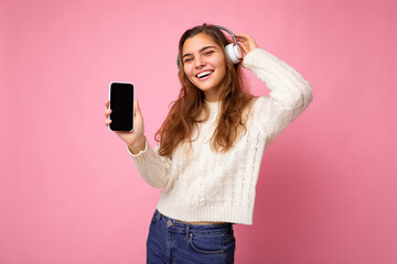 Beautiful happy smiling young woman wearing stylish casual outfit isolated on background wall...