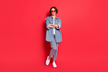 Full length body size photo girl smiling wearing sunglass confident folded hands isolated vibrant red color background