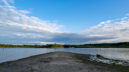 Aerial view of a beautiful and dramatic sunset over a forest lake reflected in the water, landscape drone shot. Blakheide, Beerse, Belgium. High quality photo