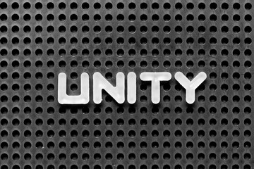 White alphabet letter in word unity on black pegboard background