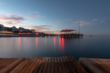 Obraz premium Close up of pier on the sea beach shot with long exposure at dusk time. Selective focus. Copy space.