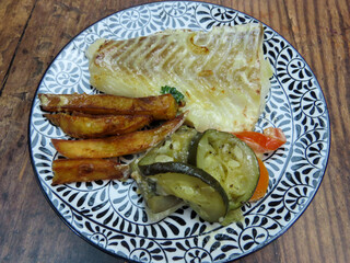 Filet de poisson, frites et légumes sur une assiette