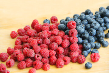 raspberries and blueberries on wooden table