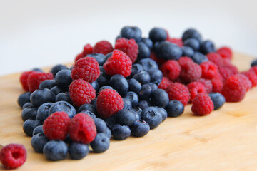 raspberries and blueberries on wooden table