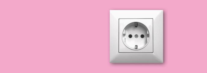 House electricity and outlet concept background and banner, EU electric socket on a pink wall, copy space photo