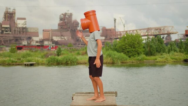Dancing man funny, happy rhythmically waving his arms against industrial background. Playful crazy robot dance emotions. Pipe people.