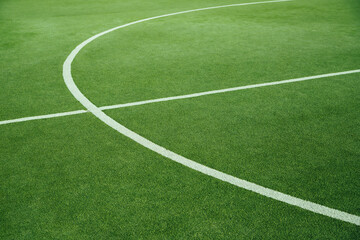 A green football field. A field of artificial grass in a school or public park.