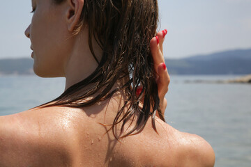 Woman's hair on the beach. Wet hair close up image. Hair damage due to salty ocean water and sun,...