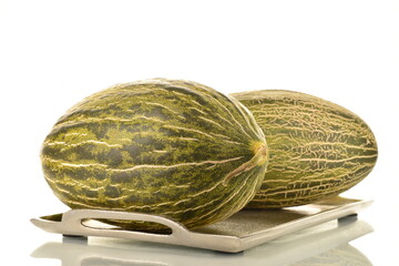Two juicy organic melons on a metal tray, close-up, isolated on white.