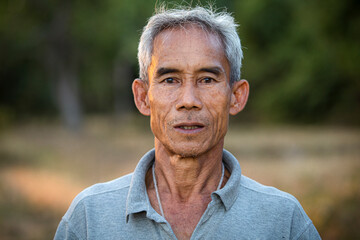 Portrait of older male farmer in rural at farm in Thailand, outdoors.