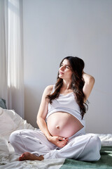 a beautiful pregnant woman smiles and looks away