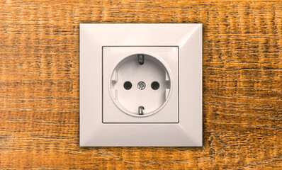 Electric outlet on wooden wall in house interior close-up, EU socket photo