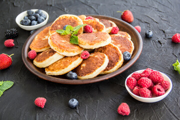 A healthy breakfast of cheese pancakes, berries, and honey. Creative atmospheric decoration