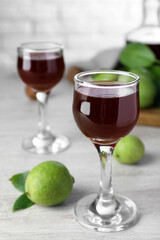 Delicious liqueur and green walnuts on wooden table