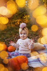 cute little girl sitting in autumn park with lights