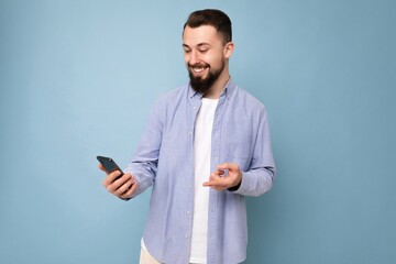 handsome young brunette unshaven man with beard wearing stylish white t-shirt and blue shirt...