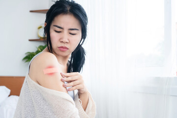 Asian woman having side effects with allergy rash skin on the shoulder after vaccination for covid-19