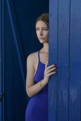 Fashion portrait of beautiful calm woman in blue dress in Mediterranean Greek environment