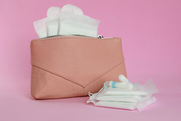 Bag with menstrual pads, pantyliners and tampons on pink background