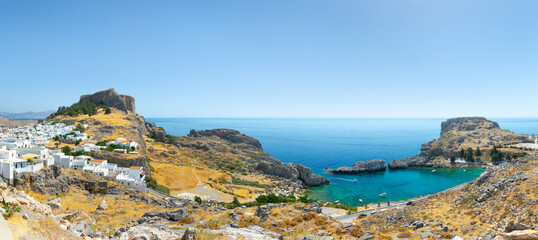 Lindos, with its ancient acropolis, ruins fortress and closed bays in sea coast, is the most view place of Rhodes island in Dodecanese, Greece. Vacation on Greece islands in Mediterranean sea. - obrazy, fototapety, plakaty