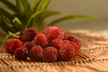 Raspberry berries close-up. A bunch of berries lying on a bamboo substrate.