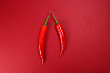 whole red chilli pepper on red paper background