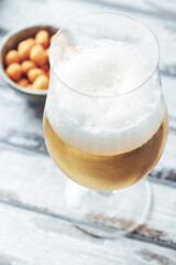 Glass of beer on bright wooden background. Close up.