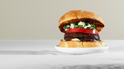Vegan sandwich burger with roasted eggplant, feta cheese and cilantro. Plant based food concept