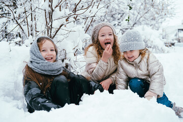 Fototapeta na wymiar Three girls playing with snow outdoor in the park, winter activity,seasonal holidays.