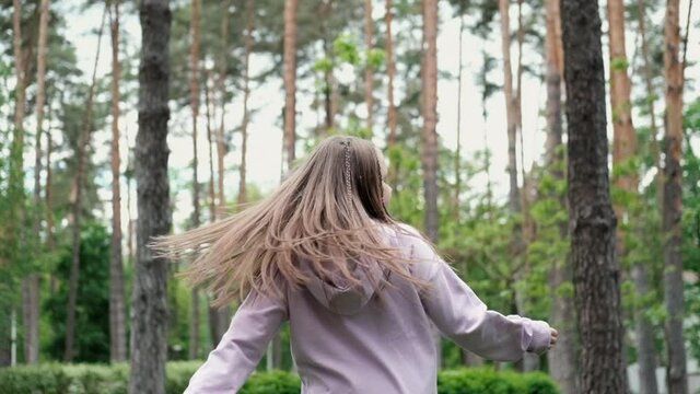 pretty girl tween teenager in purple costume having fun playing with hot air balloons outdoors. holliday, party, birthday, celebration. happy children. slow motion.