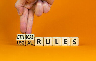 Ethical or legal rules symbol. Businessman turns wooden cubes and changes words 'ethical rules' to 'legal rules' on a beautiful orange background. Business, ethical or legal rules concept. Copy space.
