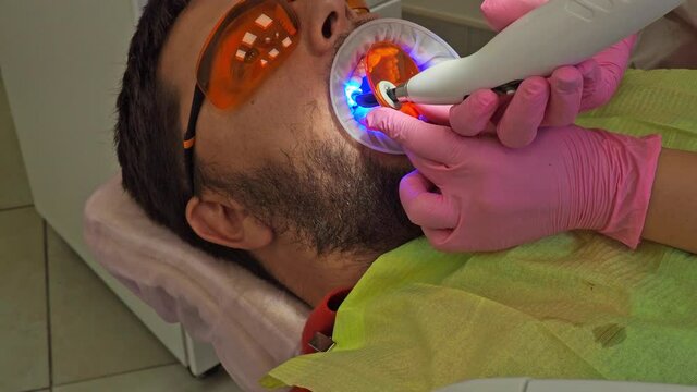 Latvia. Riga. 04.08.2019 Dentist In a Medical Gloves Works with a Patient Man in a Dental Office. Dentistry. Healthcare and Medicine Concept