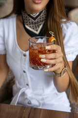 Woman hand holding cocktail glass in front of her