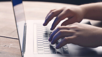 hands typing a program on a computer keyboard
