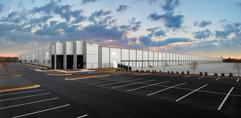 Exterior of large industrial warehouse distribution building at sunset