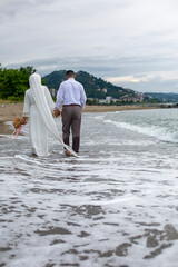 newlywed couple walking on the beach