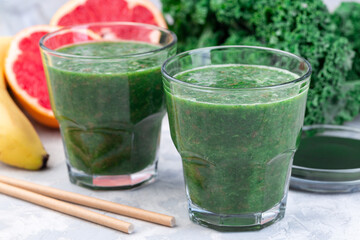 Healthy vegan green smoothie with kale, chlorella, banana and grapefruit detox drink, horizontal