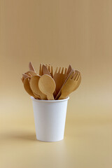Fototapeta na wymiar Disposable tableware made from natural materials, wooden spoon, fork, knife, paper cup
