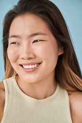 Fototapeta premium Asian lady is looking away with slight smile while posing at the camera