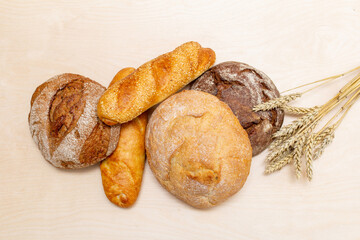 different fresh bread, rye, wheat, baguette on a wooden table top view