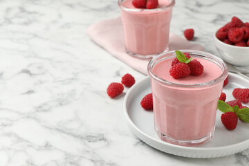 Delicious raspberry mousse with mint on white marble table, space for text