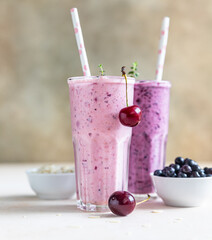 Cherry and blueberry smoothie in glass with straw. Healthy breakfast.