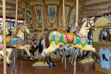 Colorful horses on a carousel at a fair in a small town in Europe.