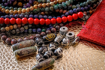 a variety of beads made of natural stones, Tibetan ji beads and metal inserts are randomly...