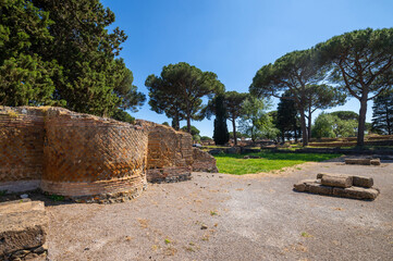 Fototapeta na wymiar Rome, Ostia Antica archaeological park Imperial era brick architectural building, beautiful Roman architectural structures of buildings in summer with blue sky maritime pines.