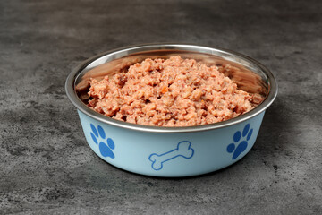 Fototapeta na wymiar Wet pet food in feeding bowl on grey stone background