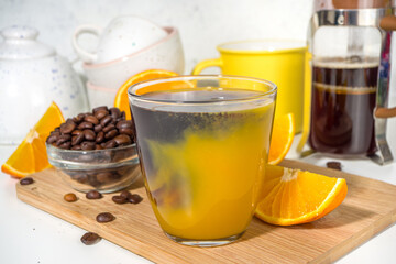 Bumble bee Coffee cocktail. Homemade hot drink with espresso and orange juice, on white kitchen table copy space