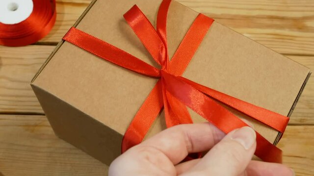 Gift parcel box with ribbon red bow, brown carton parcel, surprise