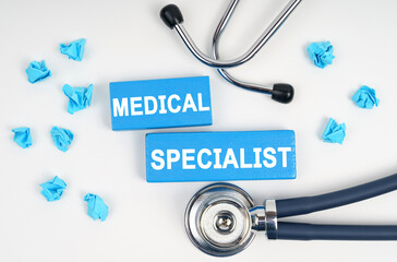 On the table is a stethoscope and blue Jenga with the inscription - MEDICAL SPECIALIST